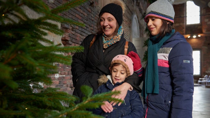 A family enjoys the Christmas tree in the Saloon at Seaton Delaval Hall